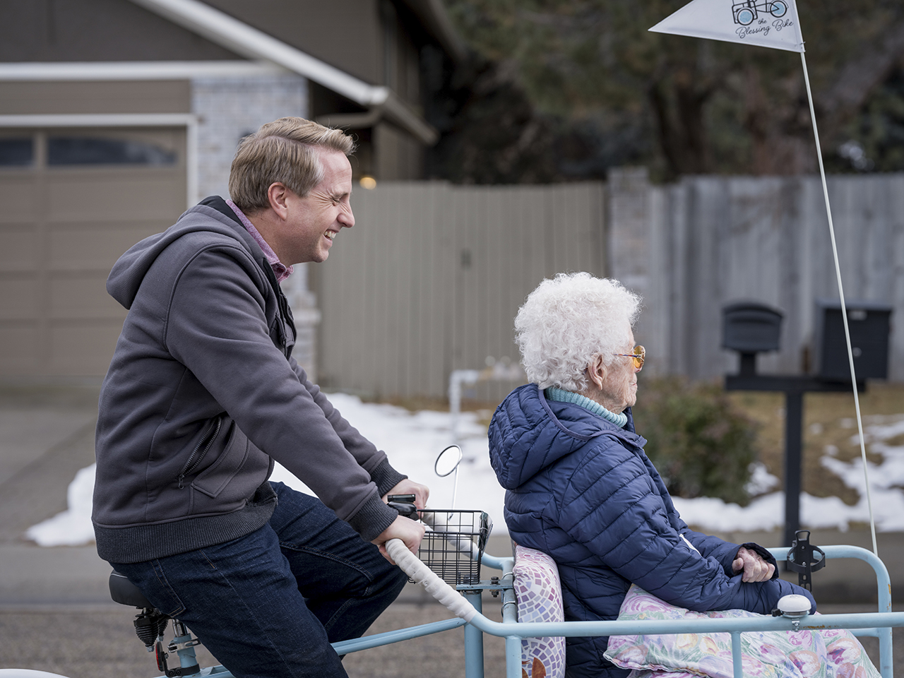 Kirby Heyborne serves an elderly woman as he volunteers as a taxi-biker